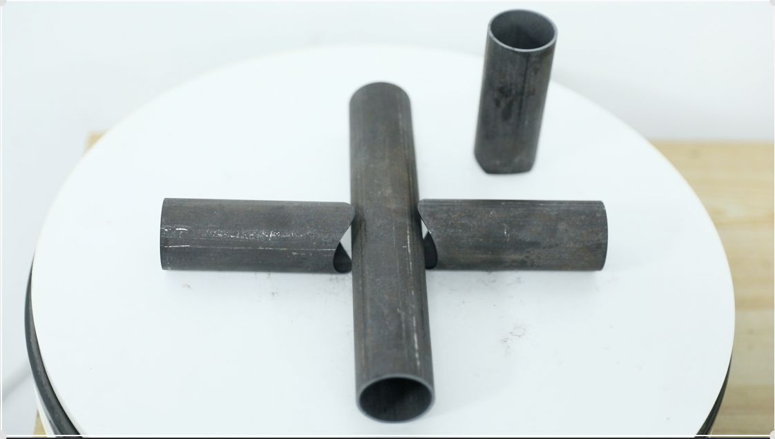 Coped structural steel tube sections arranged in a cross joint