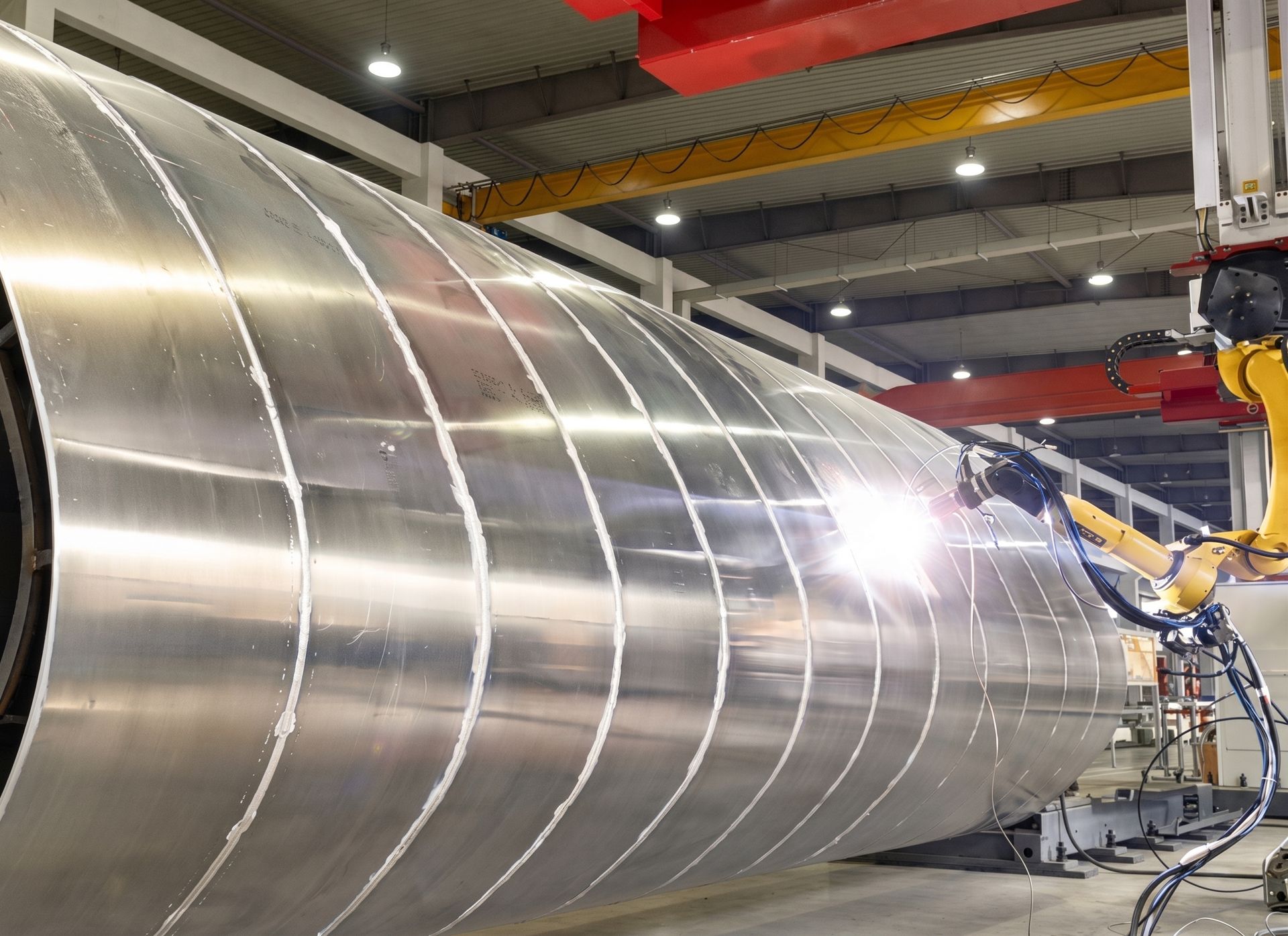 Robotic welding equipment joining a large cylindrical steel tank at Industrial Machine Worx