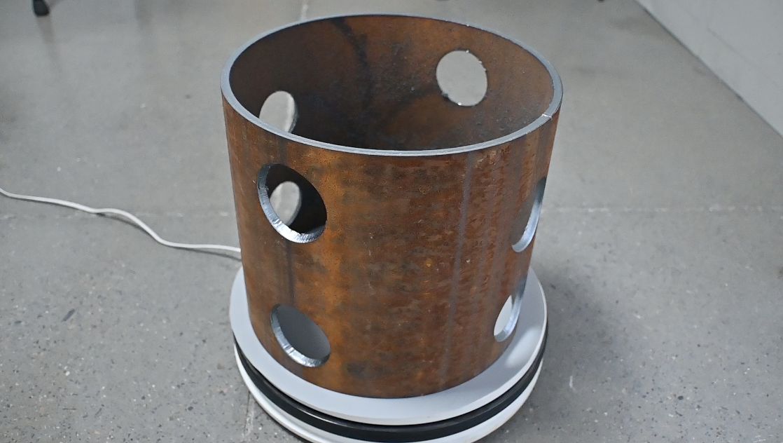 Laser-cut holes in a section of steel pipe