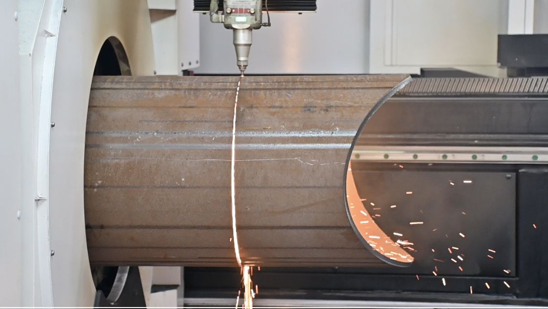 Large-diameter steel pipe held in the chuck of a tube laser