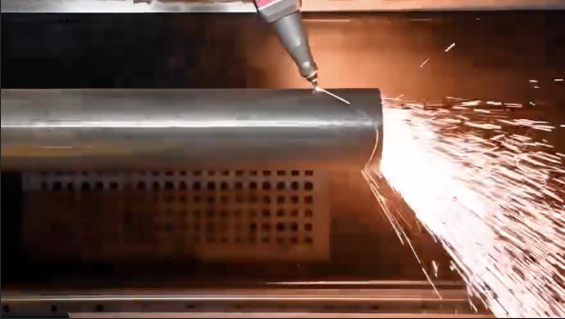 Tube laser cutting the end of a round steel tube with a shower of sparks