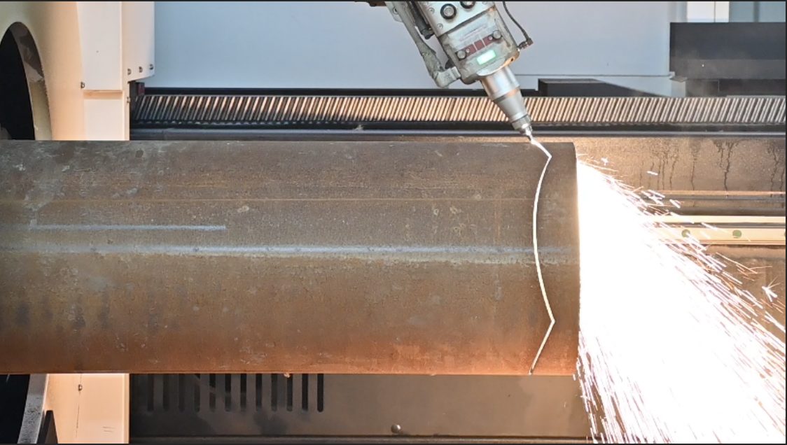 Fiber laser cutting a large round pipe, sparks flying