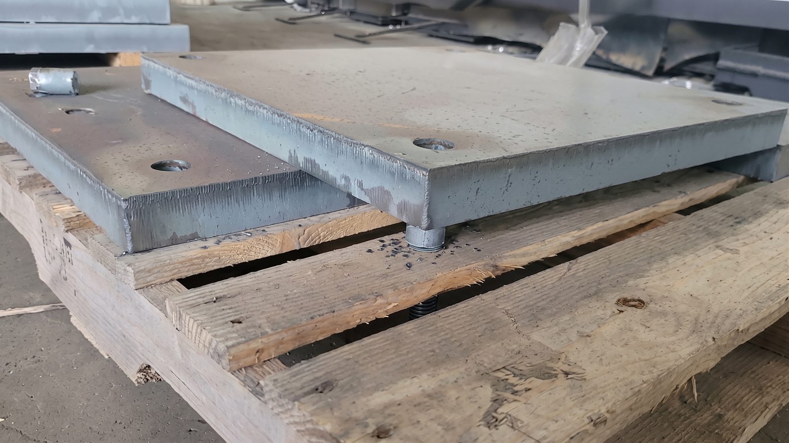 Laser-cut steel base plates staged on a pallet